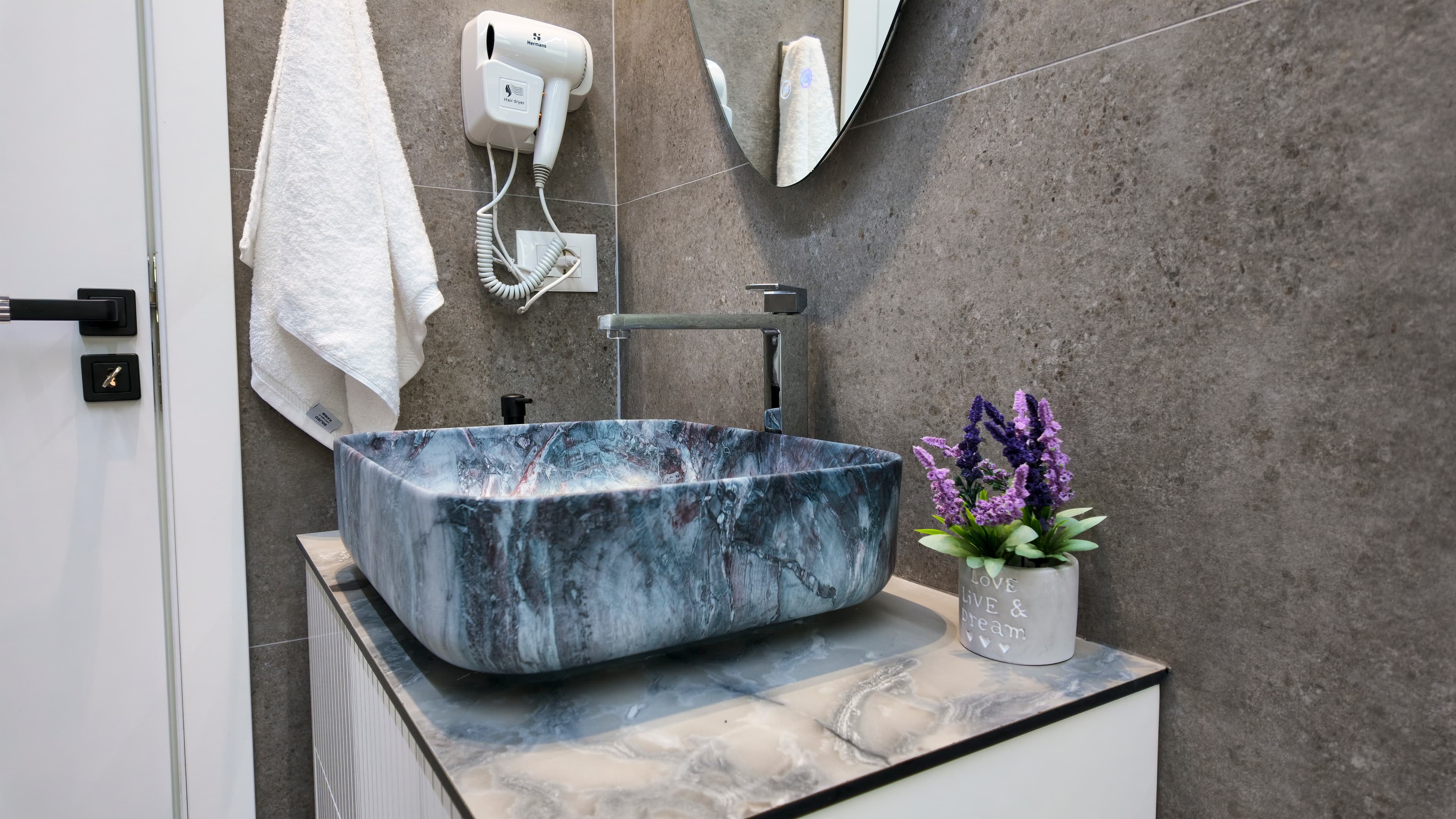 A bathroom finished in stone, with a marble basin